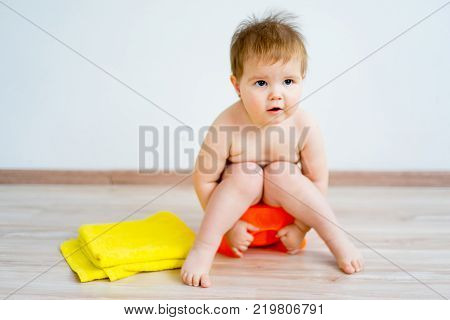 Cute smiling baby sitting on the potty