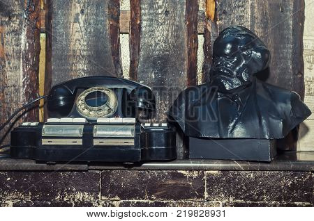 Vintage phoneon the bookshelf background. The wooden walls.