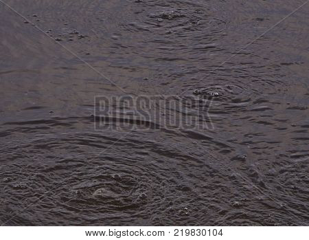 Water surface with bubbles Polluted water stream flowing.