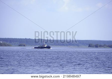 tugboat pushes sand debris along the river