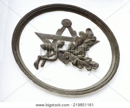 bunch of mown wheat ears with vintage handmade reaper hook sickle on white background