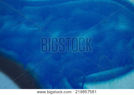 Abstract paint in hues of blue on concrete wall