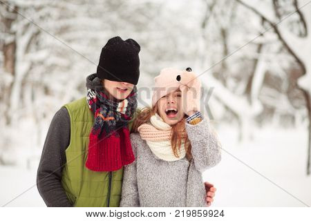 Belovers are in a winter park. Make jokes like in a childhood.