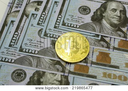 Coins bitcoin on a background of 100 American dollars close-up