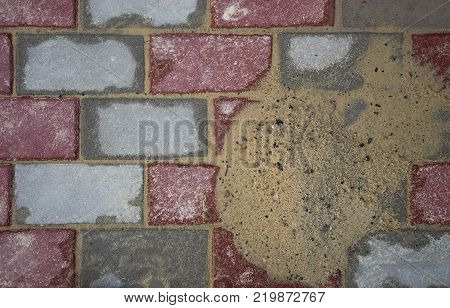 Details of the sidewalk, stone blocks, new masonry covered with sand. Brick masonry.