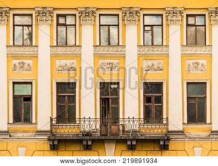 Balcony and several windows and pilasters in a row on the facade of the urban historic building front view, Saint Petersburg, Russia