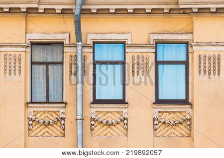 Three windows in a row on the facade of the urban historic building front view, Saint Petersburg, Russia