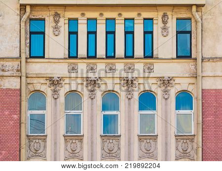 Several windows in a row on the facade of the urban historic building front view, Saint Petersburg, Russia