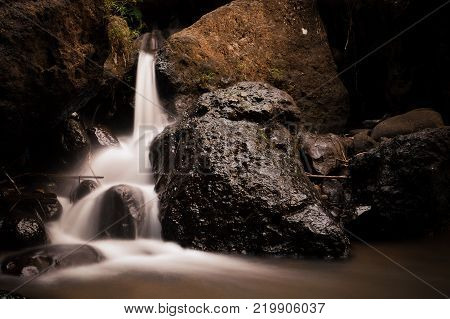 Little smooth waterfall among the stones falls in a river