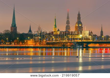 Evening view on the embankment of the Daugava River and the spiers of churches in Riga.