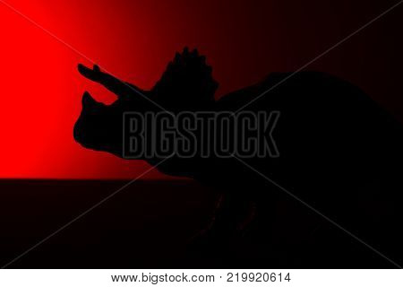 triceratops shadow with red light in dark