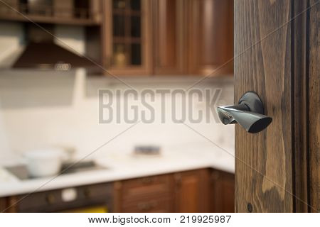 Opened wooden door to modern kitchen interior for background..