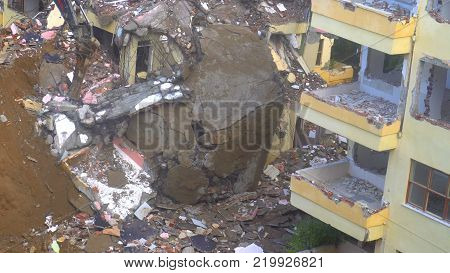 the process of destruction of the old building with heavy machinery.