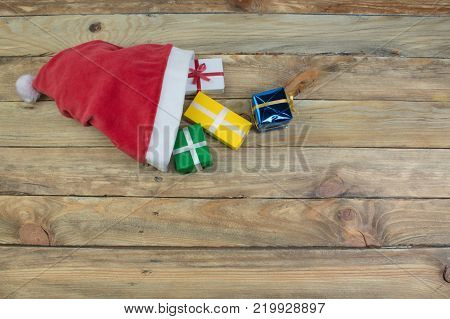 Santa red hat, Gift boxes and colorful present for christmas on blue background. Top view with copy space.