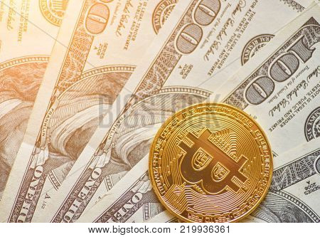 Golden metal bitcoin on dollar bills background