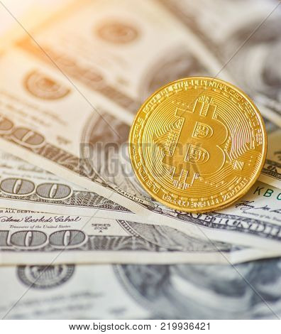Golden metal bitcoin on dollar bills background
