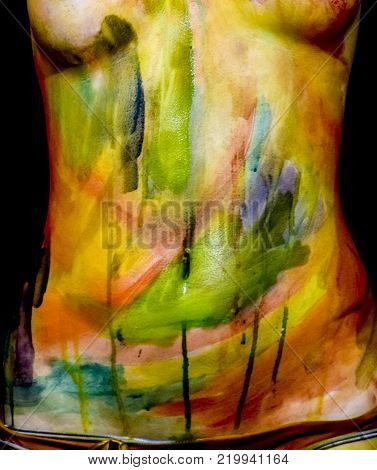 Body art. Drawing on the body. Beautiful girl with painted body watercolors. A white young girl painted the body with paint.
