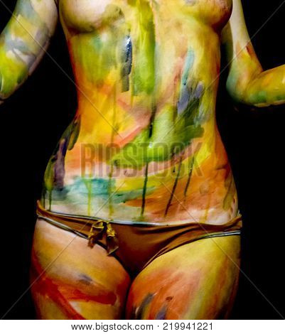 Body art. Drawing on the body. Beautiful girl with painted body watercolors. A white young girl painted the body with paint.