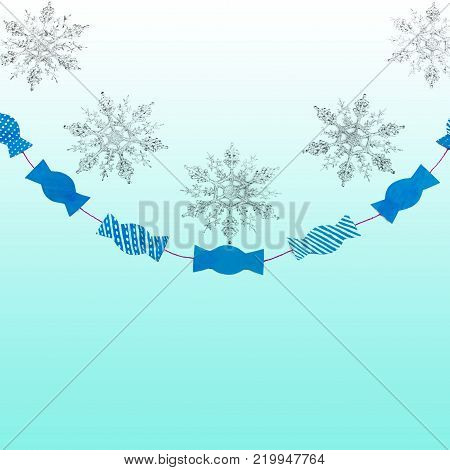 Decorative sparkly snowflakes and paper candies on white isolated background. Holiday new year garland top View Flat lay