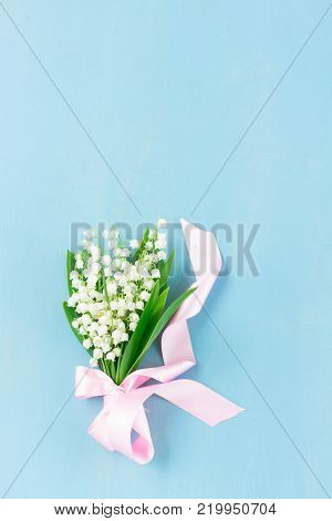 Lilly of the valley flowers on blue wooden background