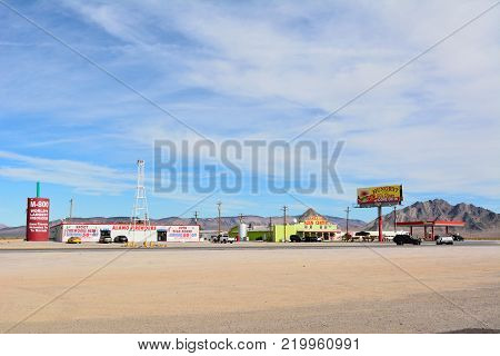 Amargosa Valley, Nevada, United States of America - November 24, 2017. Desert truck stop in Amargosa Valley with Area 51 Alien Center, commercial properties, petrol station and cars.