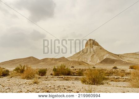 Landscape scenic view on rock and sand in dry desert in Israel. Hot middle east wilderness. Scenic outdoor view on wild land. Summer heat and sunlight, nobody on photo