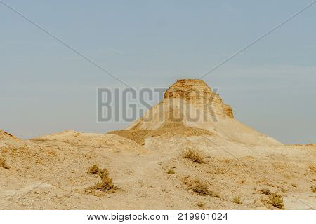 Landscape scenic view on rock in dry desert in Israel. Sand, rocks and stones in hot middle east wilderness. Scenic outdoor view on wild land. Summer heat and sunlight, nobody on photo