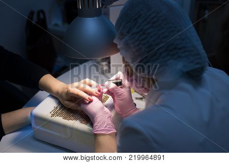 master in the beauty salon getting a manicure client
