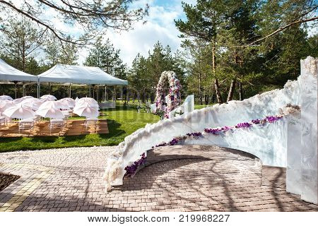 Outdoor wedding ceremony with umbrellas in the forest.