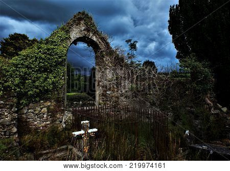 A ruin of a church with an overgrown cemetery somewhere in the Wicklow Mountains, Ireland.