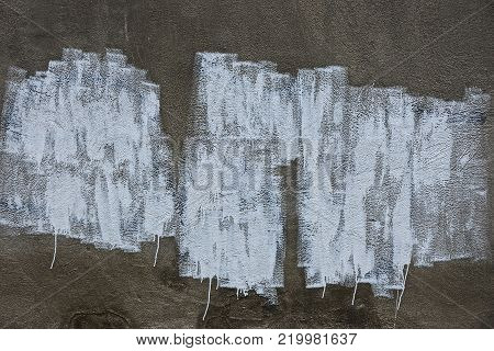 part of a gray concrete wall with white paint