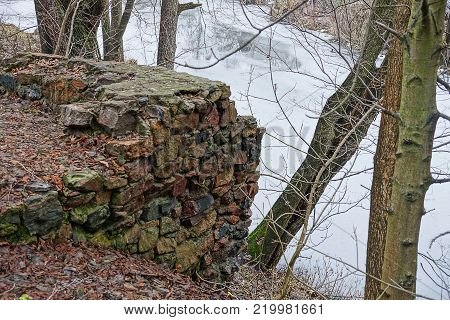 stone foundation of a ruined old house on the river bank