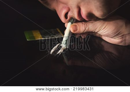 Junkie Is Snorting Cocaine Powder With Rolled Banknote.
