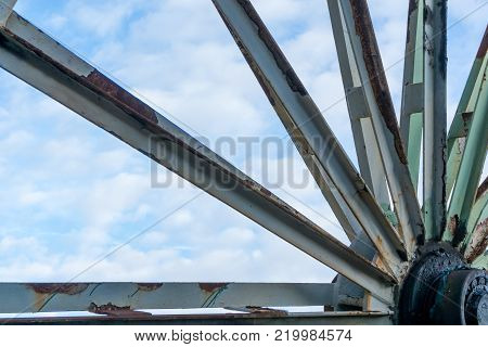Old rusty wheel in front of cloudy sky, zeche ewald germany
