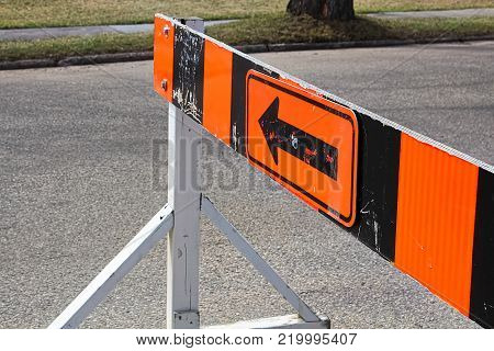 A road closer with arrow construction barrier.