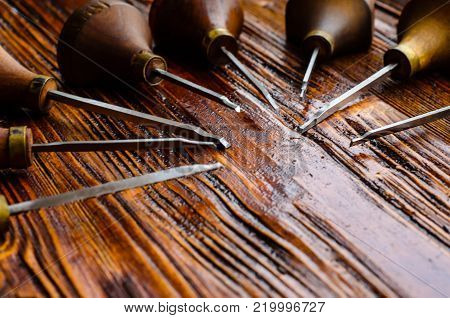 Different gravers for jewelry on a wooden background
