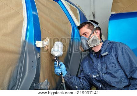 Profesional car painting in a paint booth.