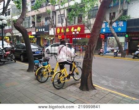 ZHONGSHAN,GUANGDONG,China-November 24,2017:girl ready to ride a shared bike.Bicycle-sharing is very popular in China.