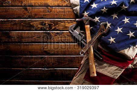 Old and worn work tools on large American flag - Labor day background