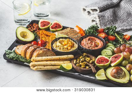 Vegan Appetizer Platter. Hummus, Tofu, Vegetables, Fruits And Bread On A Black Tray, White Backgroun