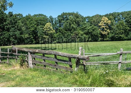 Bokrijk, Belgium - June 27, 2019: Closeup Of Old Gray Wooden Gate Closure With Tree Balance Beam To 