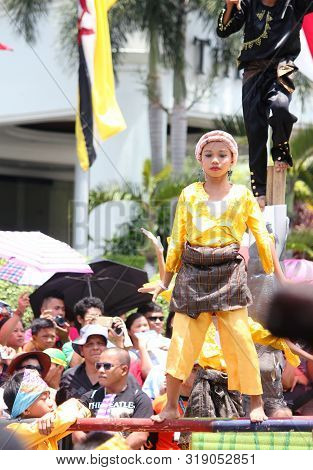Davao City, Philippines-august 2014: A Girl Balances Herself On A Bamboo Pole At A Kadawayan Streetd