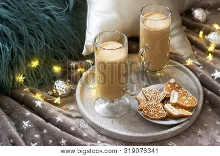 Homemade Latte In Glass Cups, Served With Gingerbread On The Background Of Plaid, Pillows And Garlan