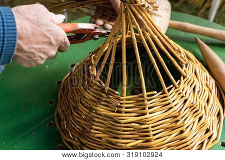 Male Hands Working On Wickerwork Basket. Handcraft Concept