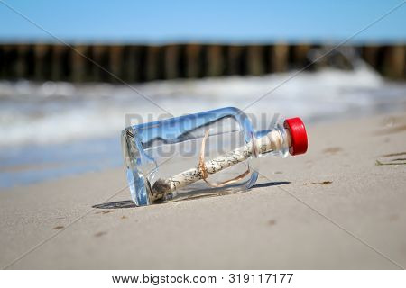 A Washed-up Bottle Post On The Beach