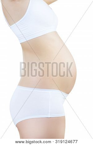 Side View On Pregnant Woman With Belly In The Early Stages Of Pregnancy In White Underwear. Maternit