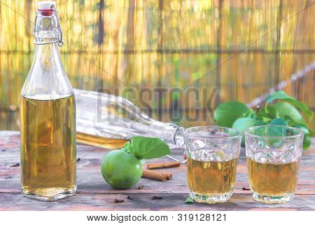 Apple Cider Poured Into Bottles. Glasses Filled With Apple Cider Vinegar Stand On An Old Vintage Tab