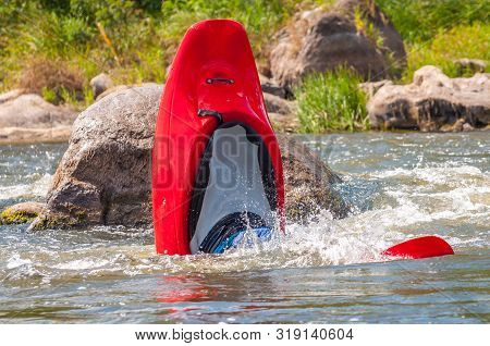 Playboating. A Man Sitting In A Kayak With Oars In His Hands Performs Exercises On The Water. Kayaki