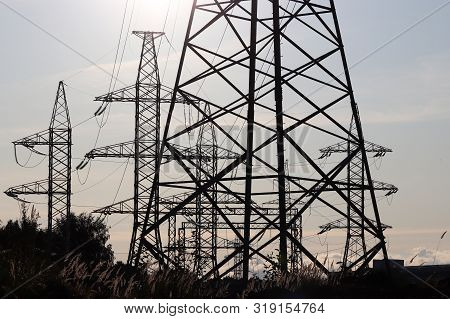 Power Plant, Electricity Transmission Lines. Silhouettes Of High Voltage Towers With Electrical Wire