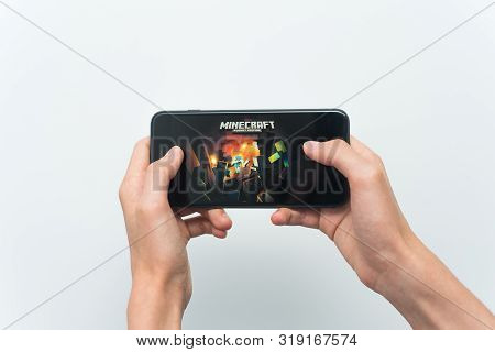 Samara, Russia -07, 29, 2019: A Young Guy Playing Minecraft Game On Iphone 8 Plus. Teenage Boy Holdi
